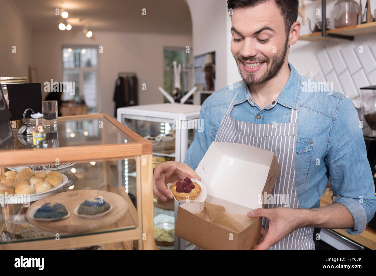 Waiter Box Cheerful attractive waiter putting cakes into the box Stock Photo - Alamy