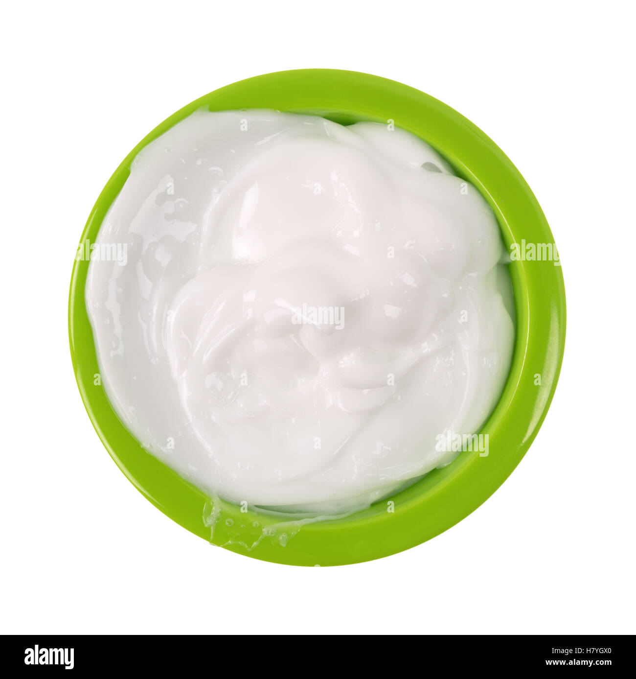 A small green bowl messily filled with vitamin E lotion isolated on a white background. Stock Photo