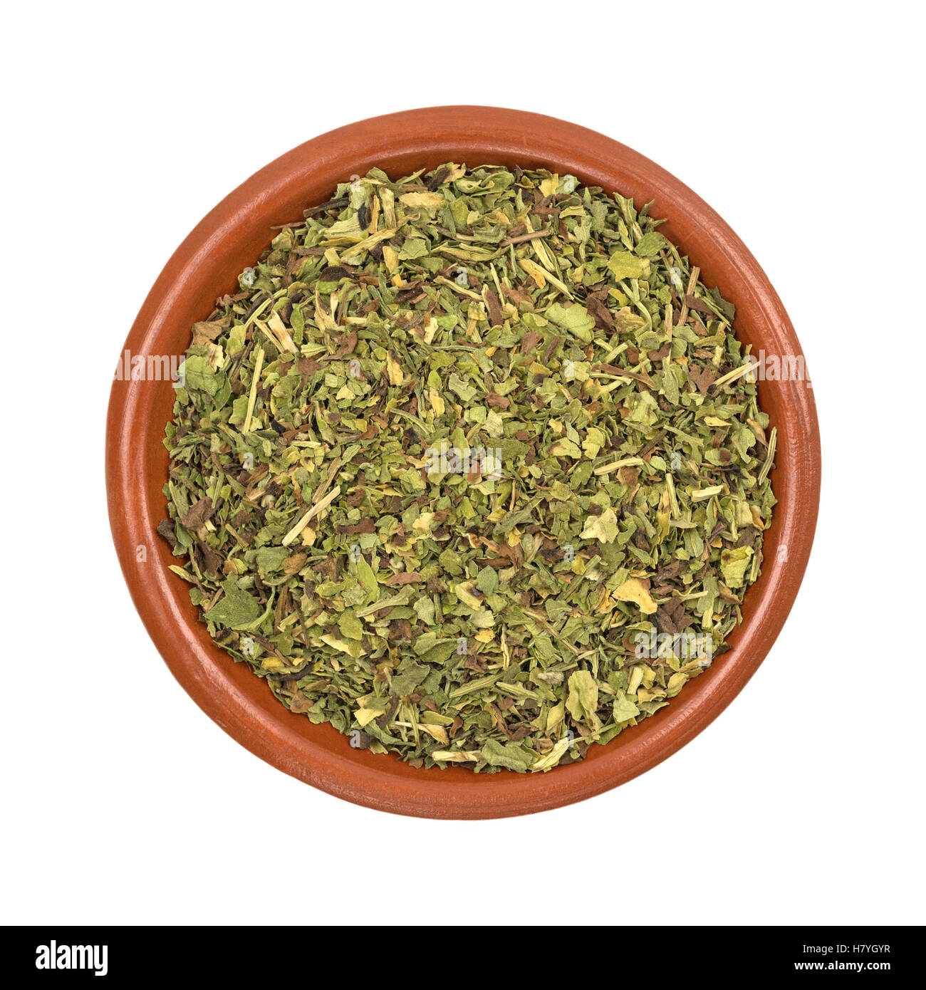 Top view of a small bowl filled with feverfew herb isolated on a white background. Stock Photo