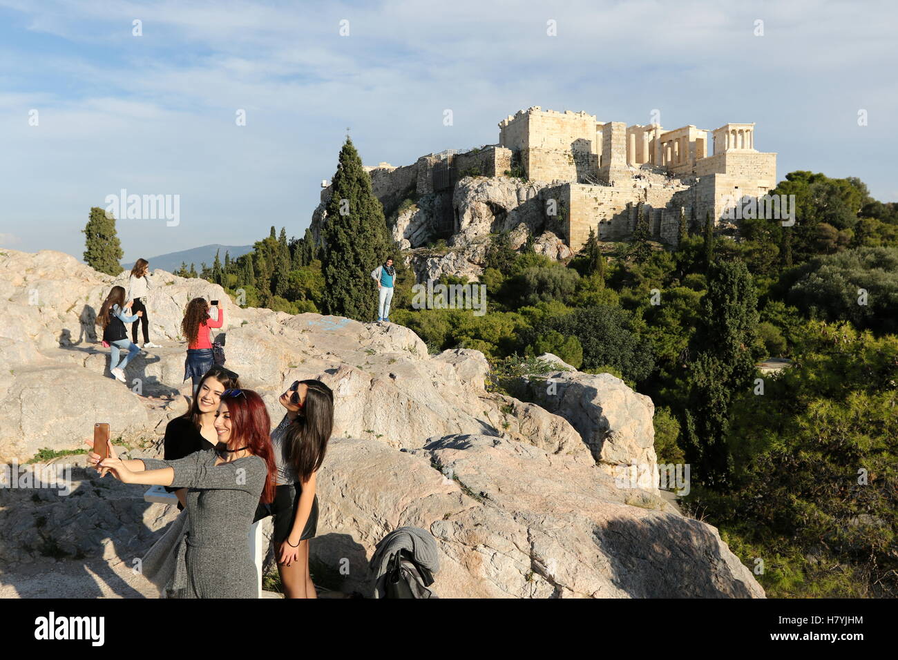 Young women taking a photograph of themselves at Areopagus hill, overlooking the Acropolis in Athens Greece Stock Photo