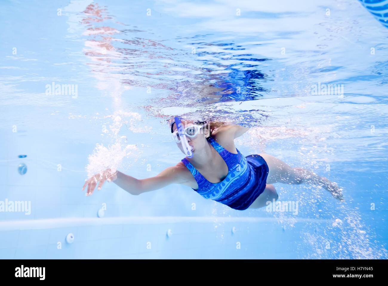 Young woman practicing swimming in lap pool with swimmer snorkel and googles Stock Photo