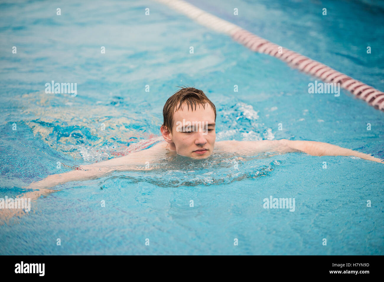 man swims using the crawl stroke in indoor pool Stock Photo - Alamy