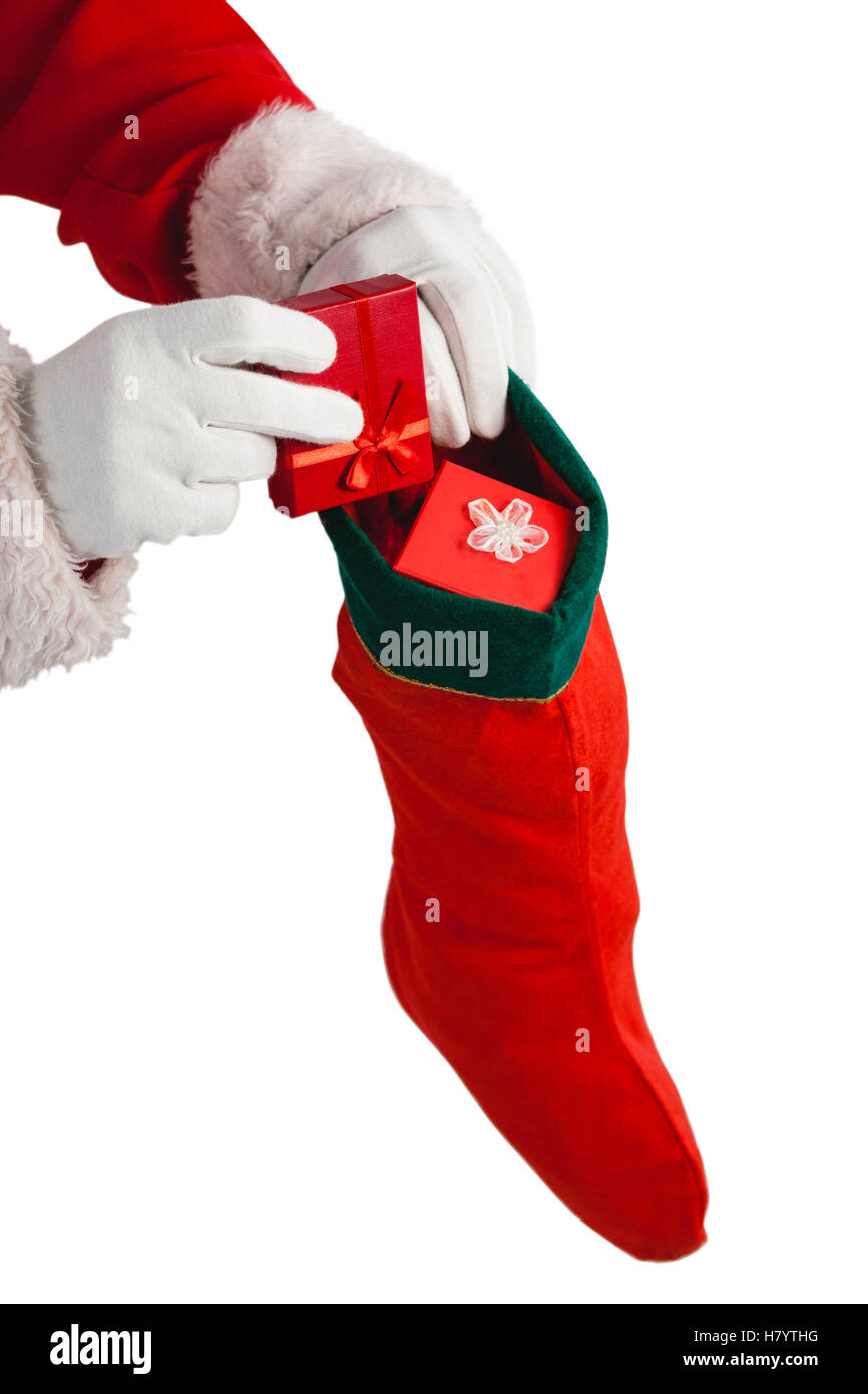Santa claus putting presents in christmas stockings Stock Photo Alamy