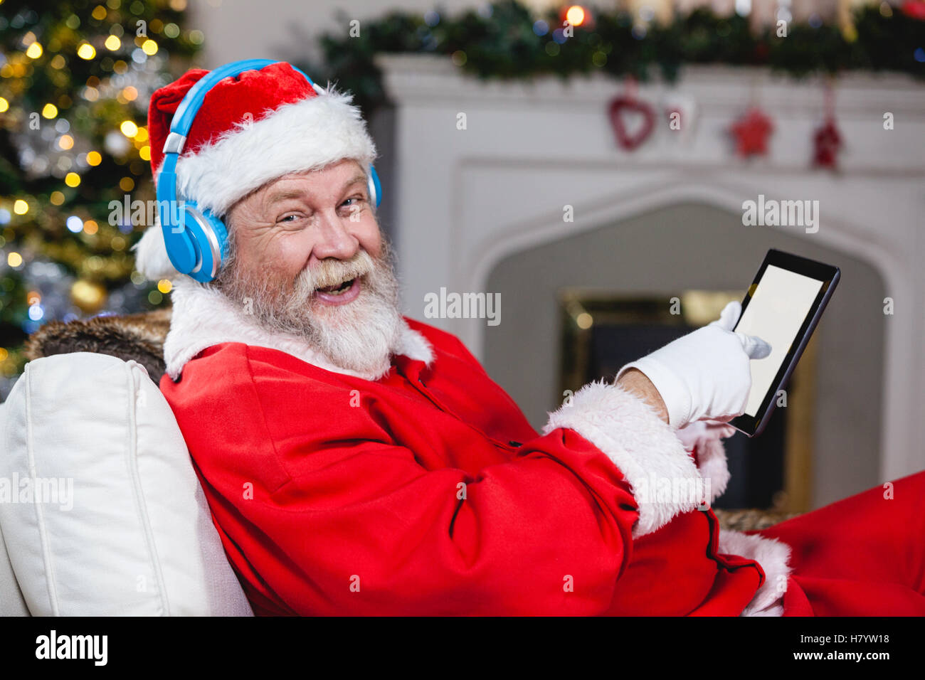 Santa claus using digital tablet at home Stock Photo - Alamy