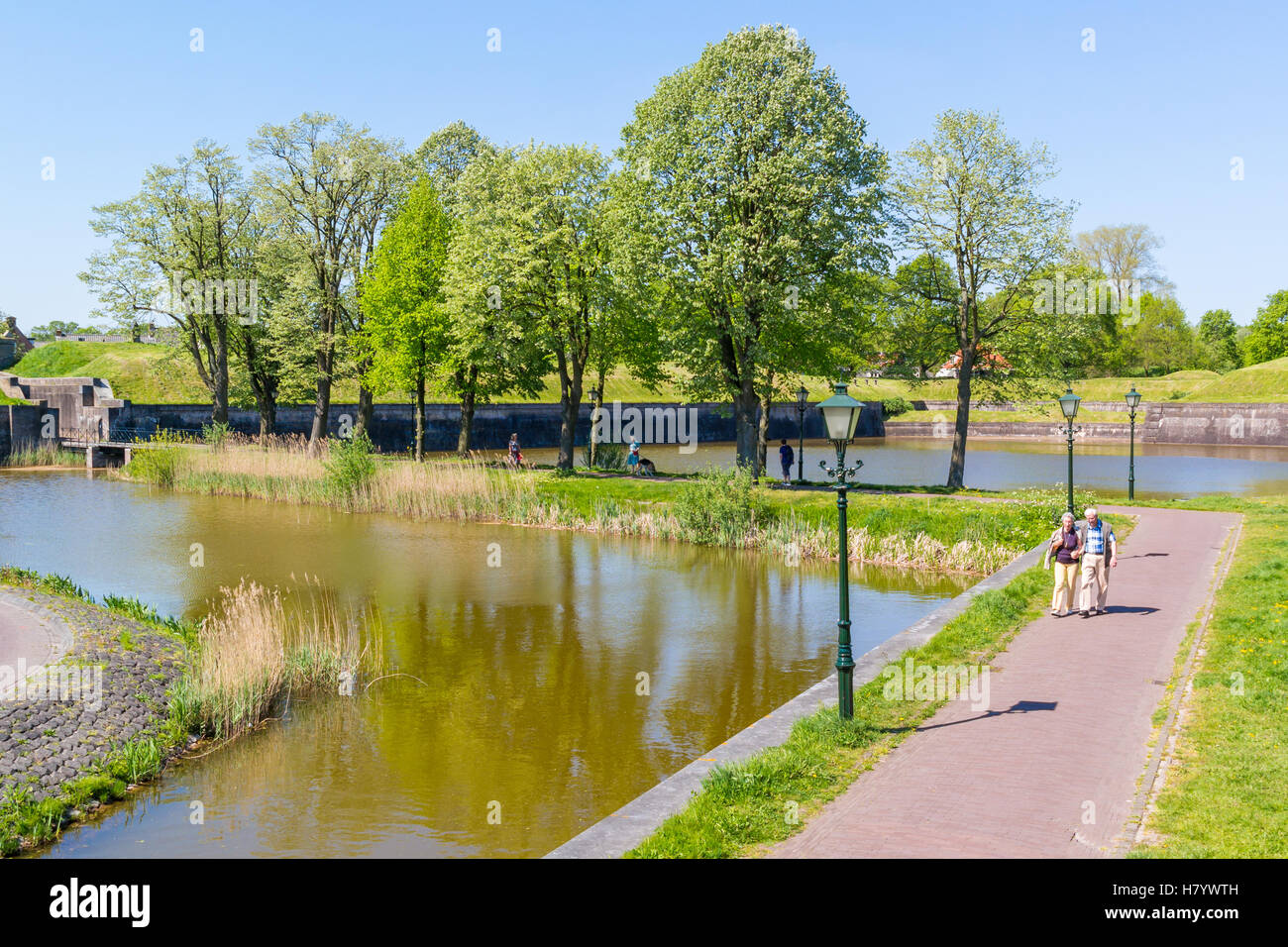 Active senior people walking and ramparts of old fortified town of Naarden, North Holland, Netherlands Stock Photo