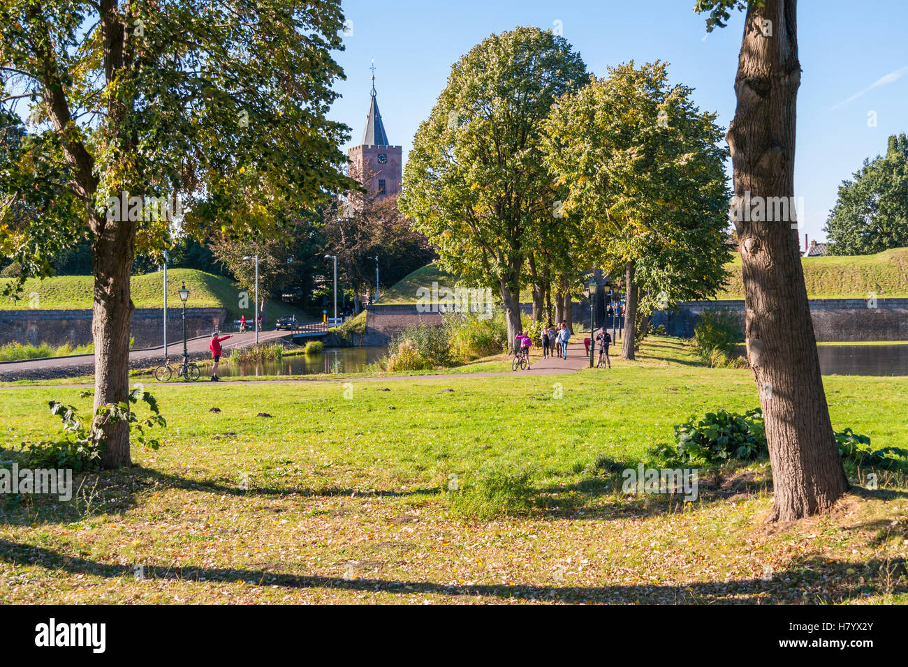 Autumn in old fortified town of Naarden with people, church tower and rampart, Netherlands Stock Photo