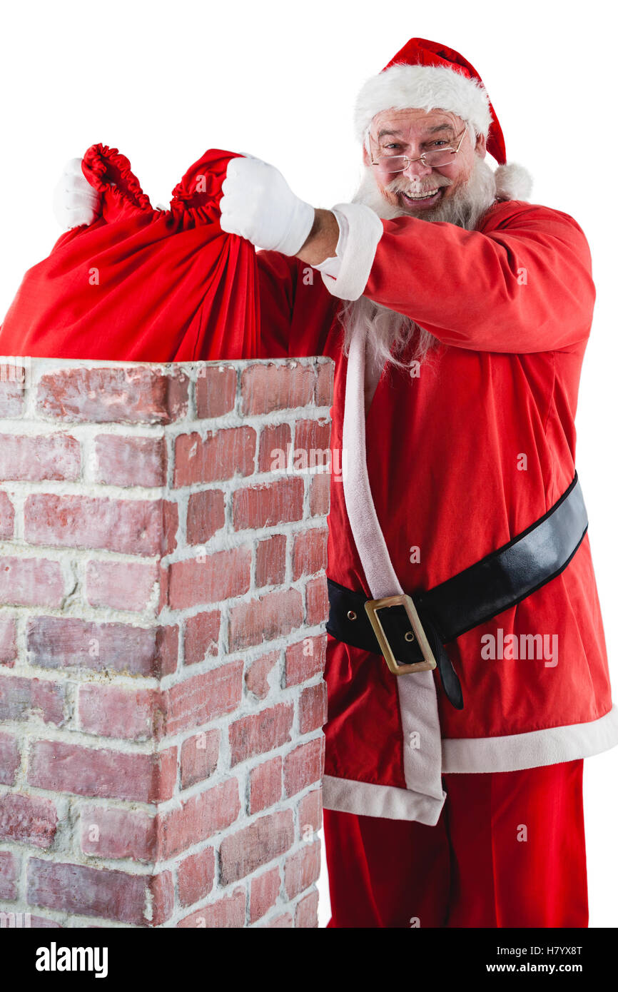 Santa claus placing gift box into a chimney Stock Photo - Alamy