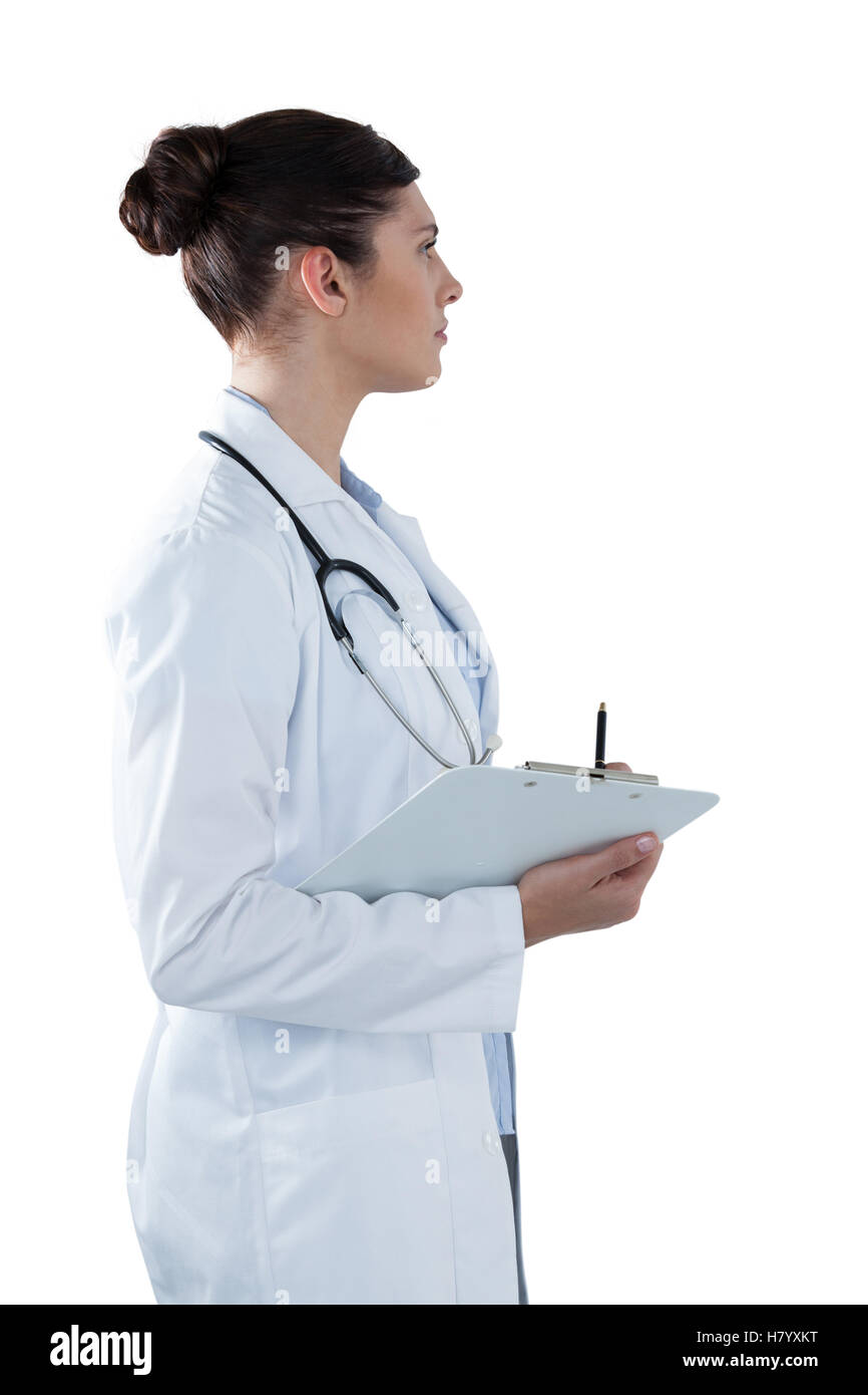 Female doctor holding clipboard and looking away Stock Photo - Alamy
