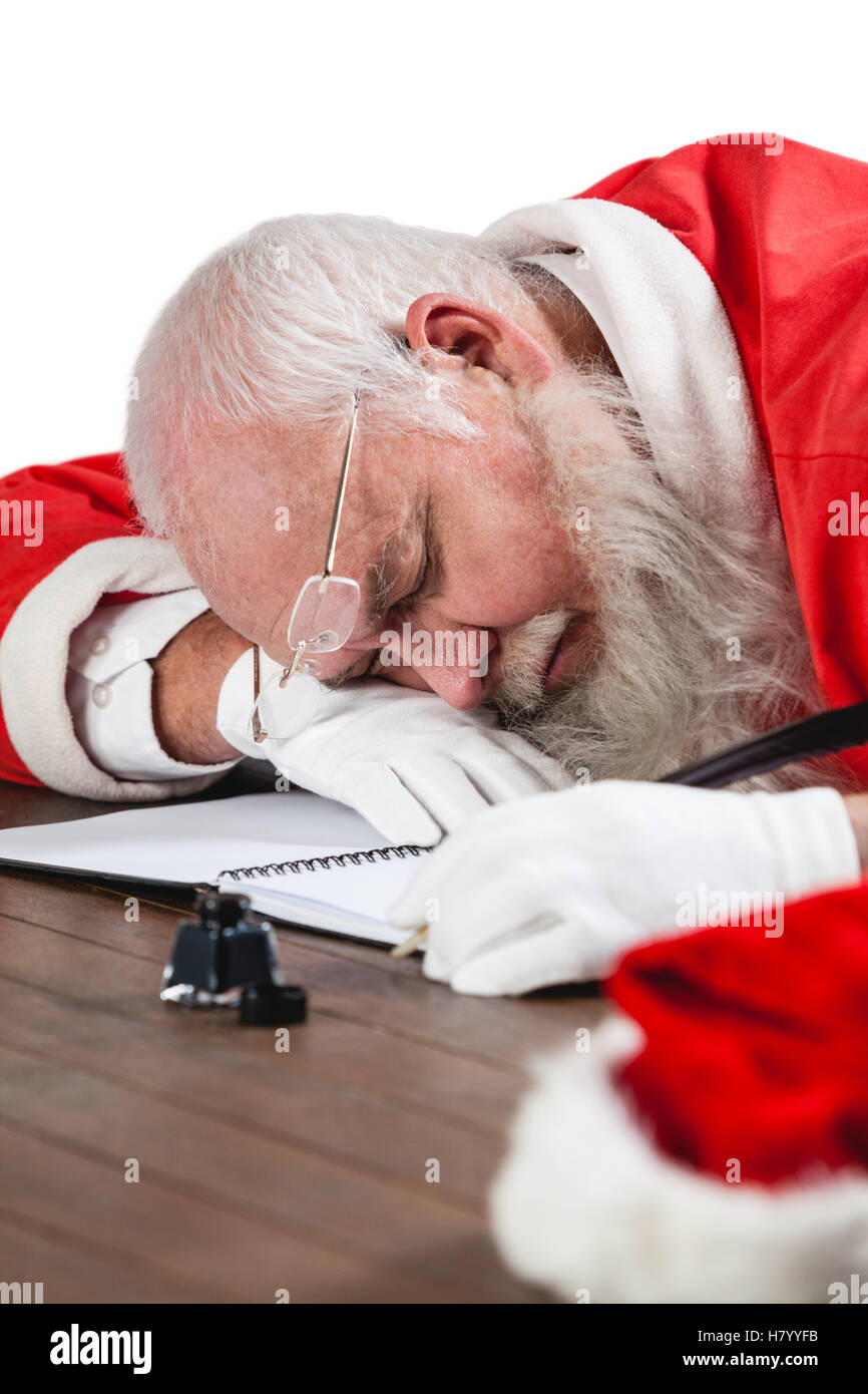 Santa claus sleeping at desk while writing a letter with a quill Stock Photo