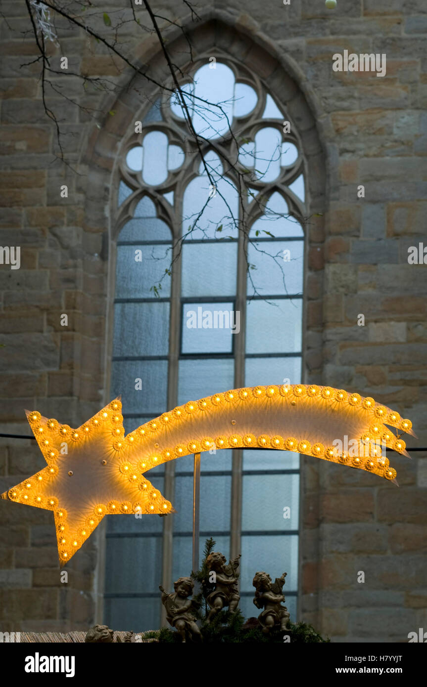 Illuminated Christmas star in front of a stained glass window Stock Photo