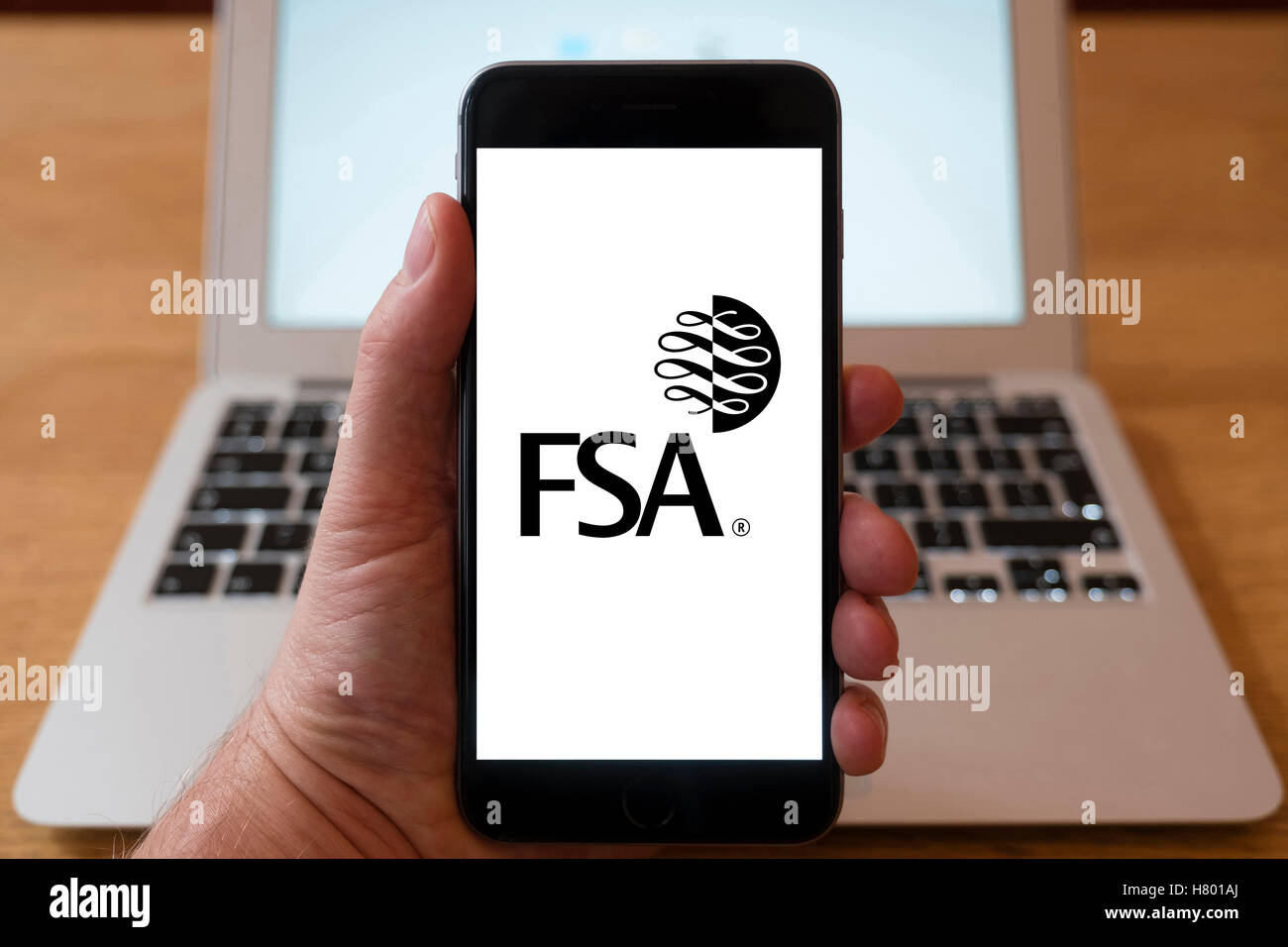 Using iPhone smartphone to display logo of FSA, Financial Services Authority Stock Photo