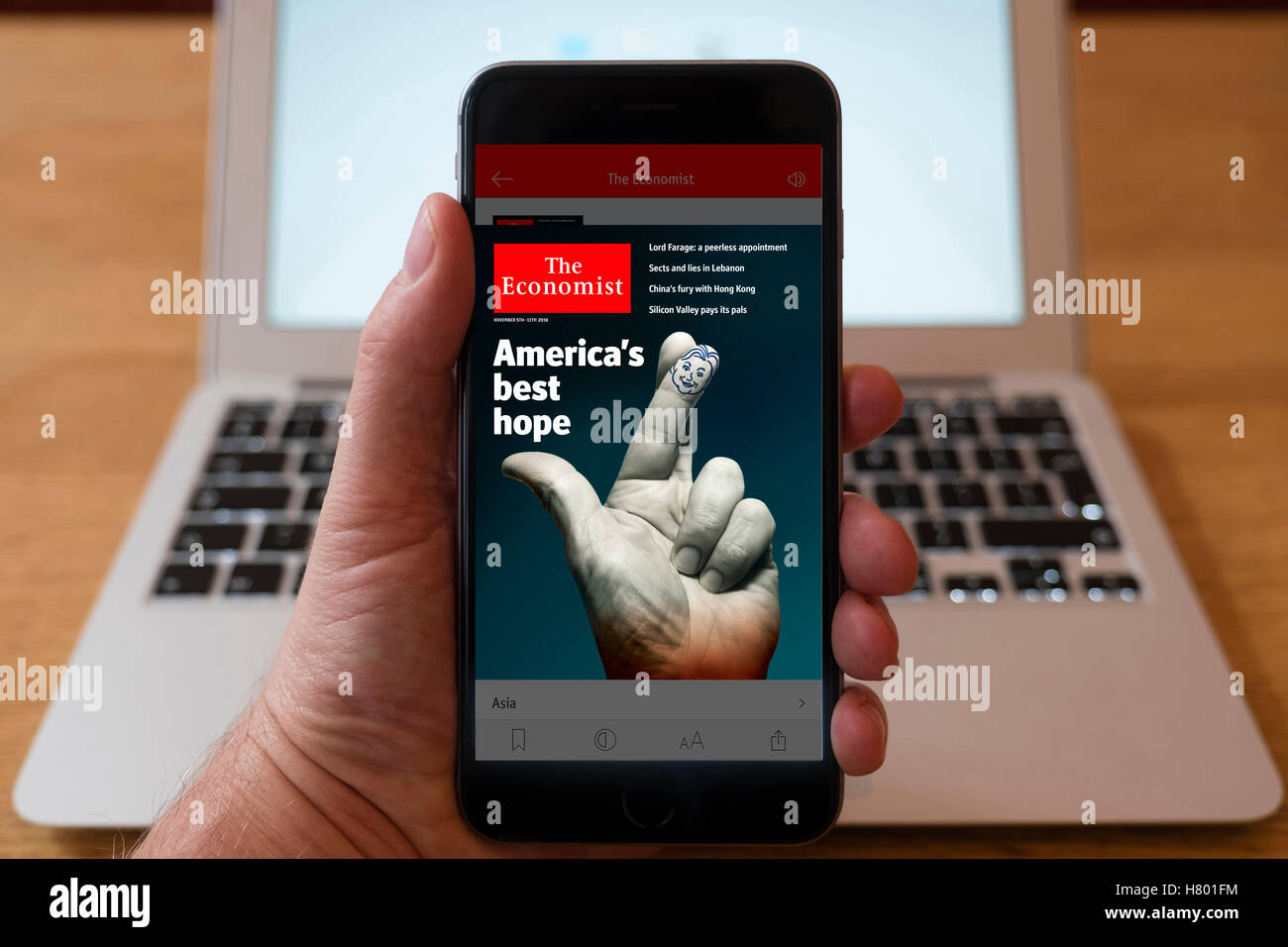 Using iPhone smartphone to display front page of The Economist current affairs newspaper Stock Photo