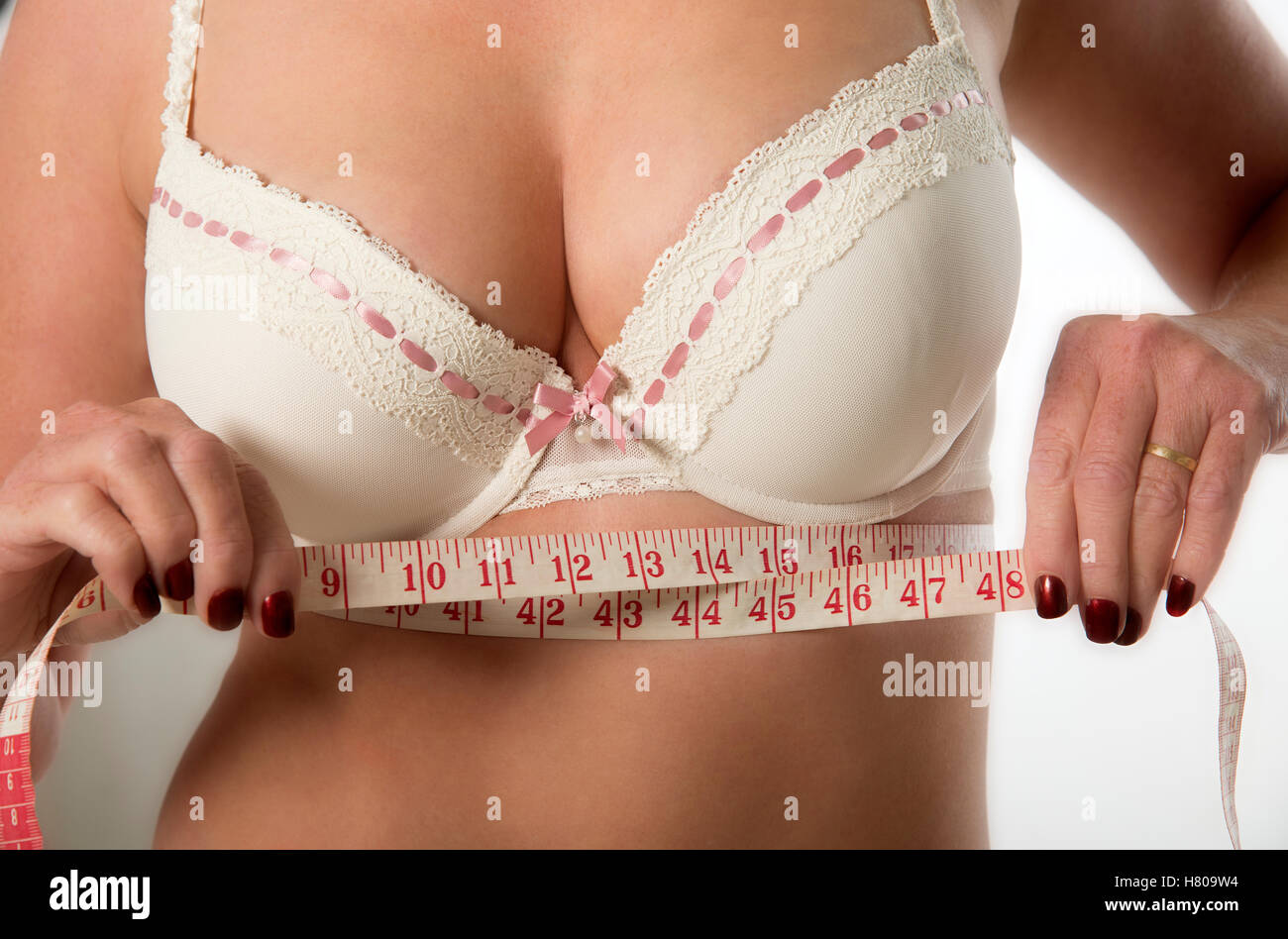 Middle aged woman checking under bra measurement using a tape measure Stock Photo