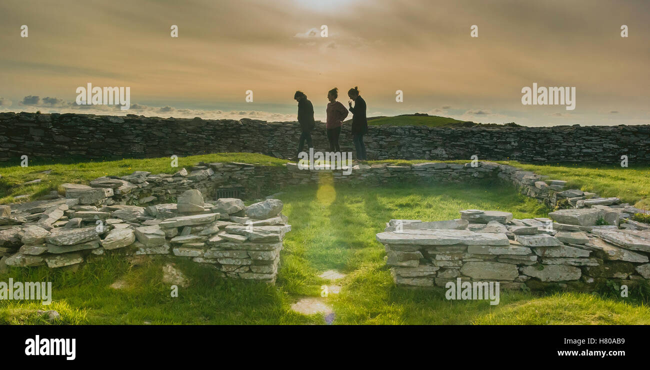 Three friends in a consort at sunset at an ancient irish fortification Stock Photo