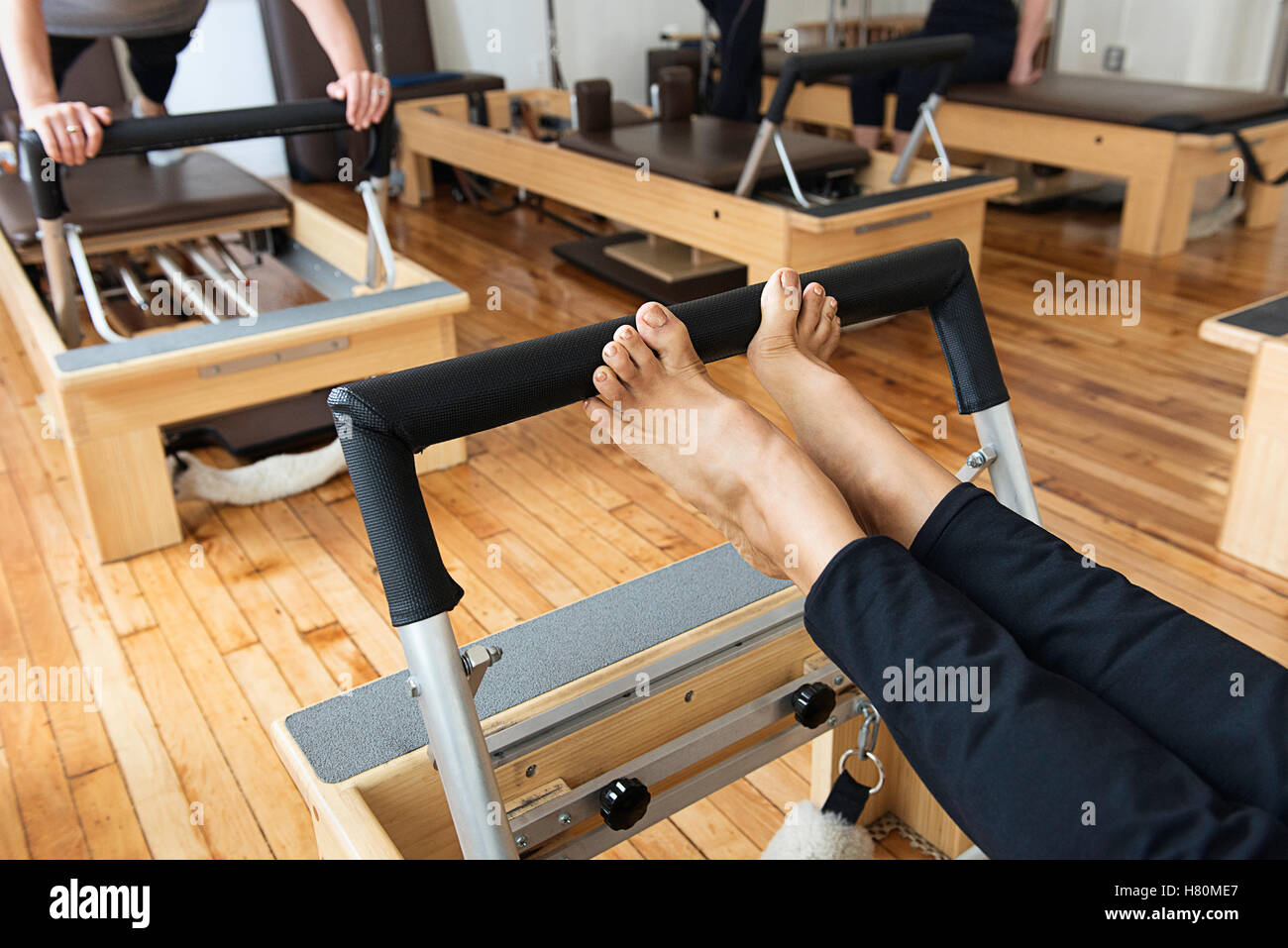 People working out on reformer machines. Stock Photo