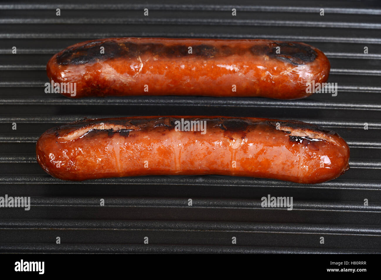 sausages cooking on a grill Stock Photo