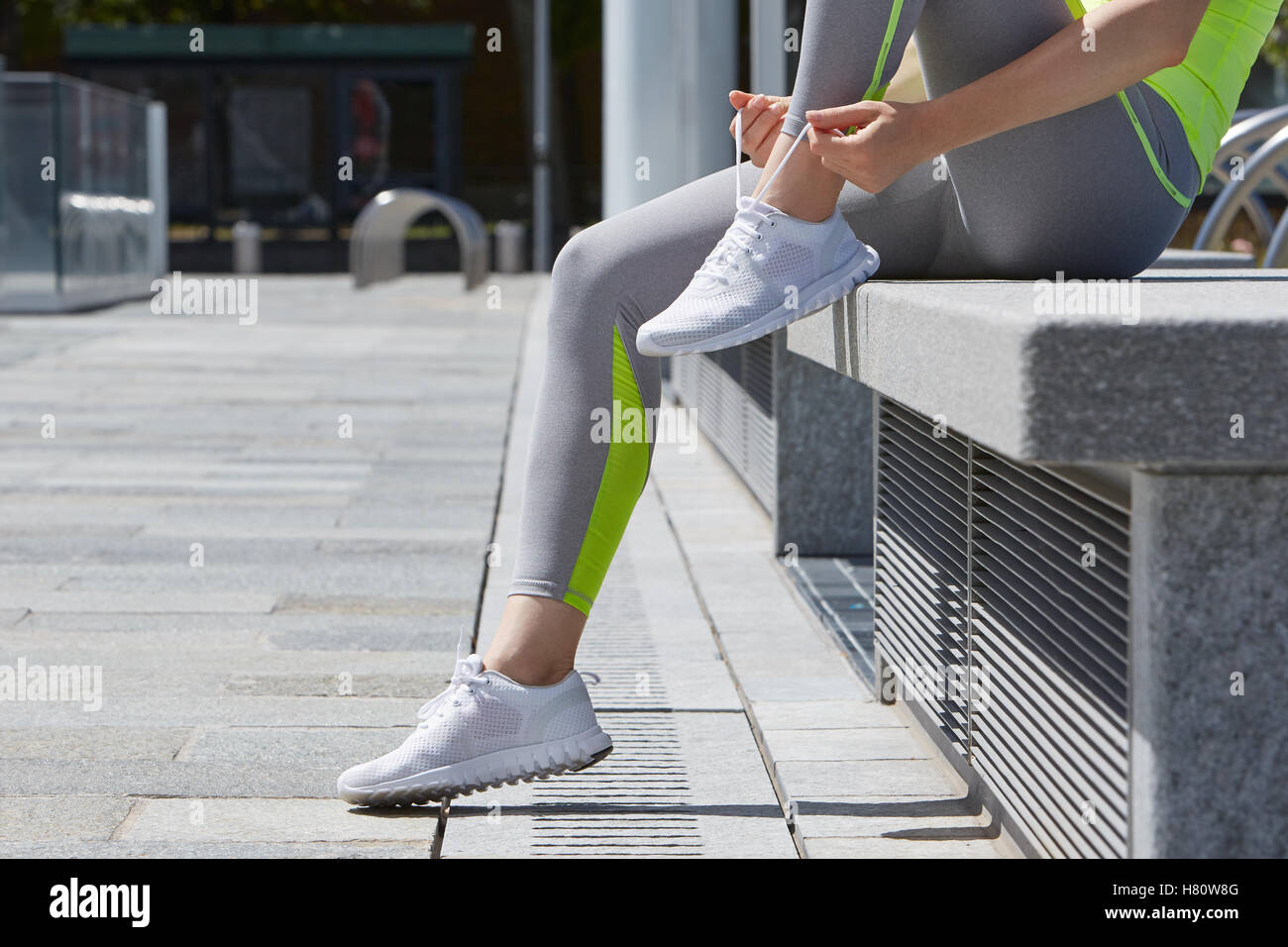 Woman tying shoelaces before running outdoor in the city Stock Photo