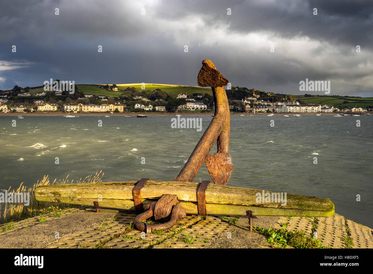 The anchor on the quayside at Appledore during stormy weather over Instow in north Devon. Stock Photo
