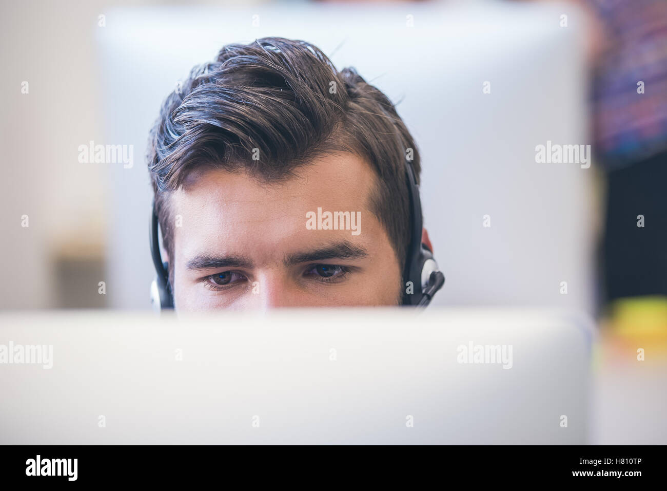 Thoughtful young programmer coding on computer Stock Photo
