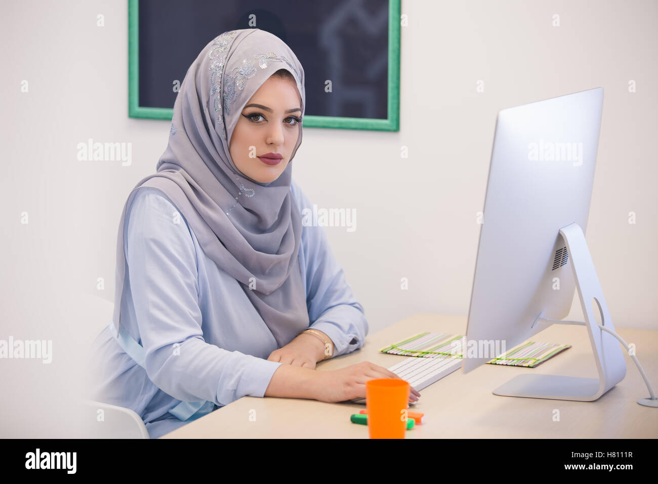 Attractive Muslim young woman working in office on computer Stock Photo ...
