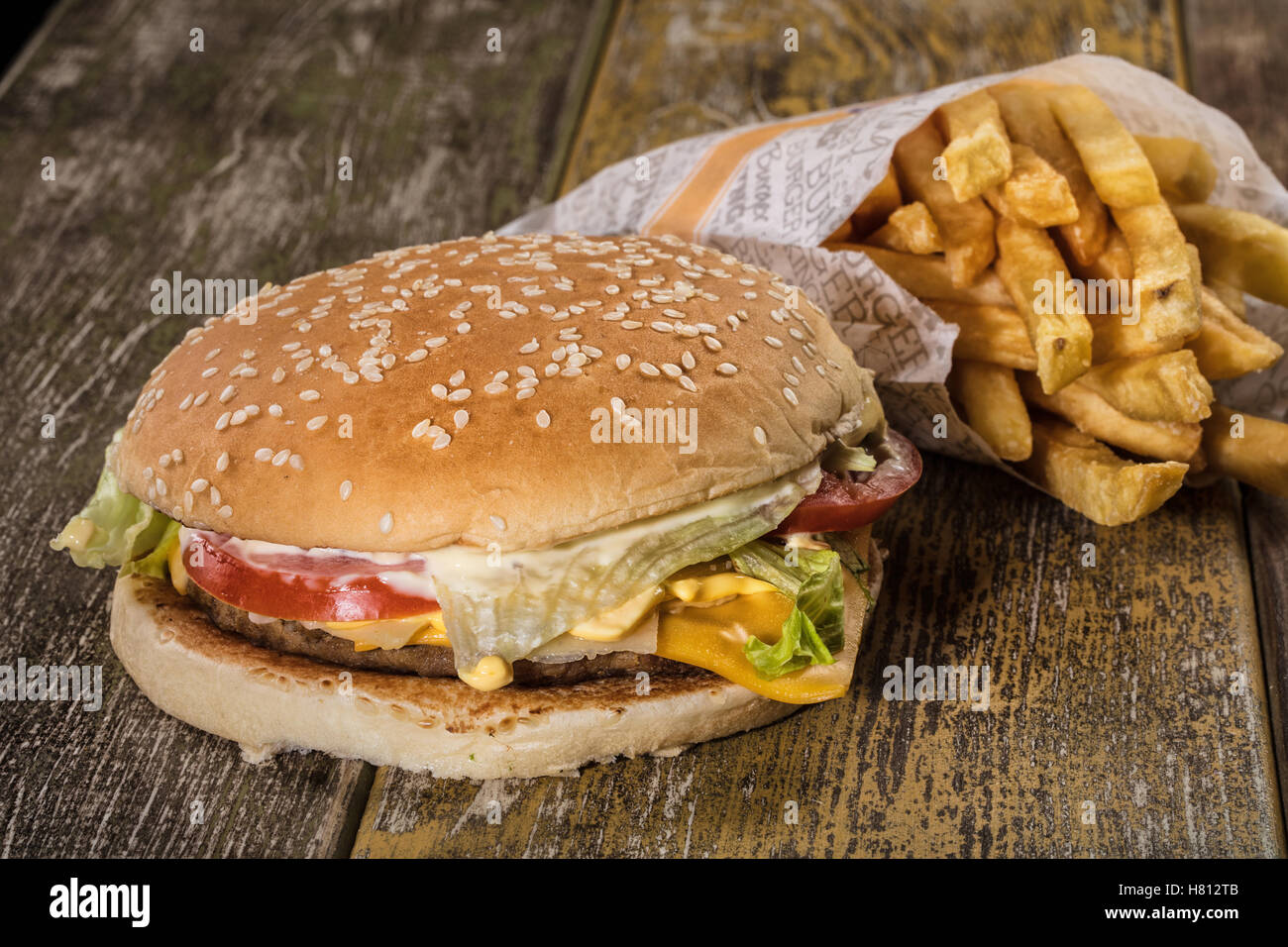Hamburger and fried potato on an old wooden desk Stock Photo