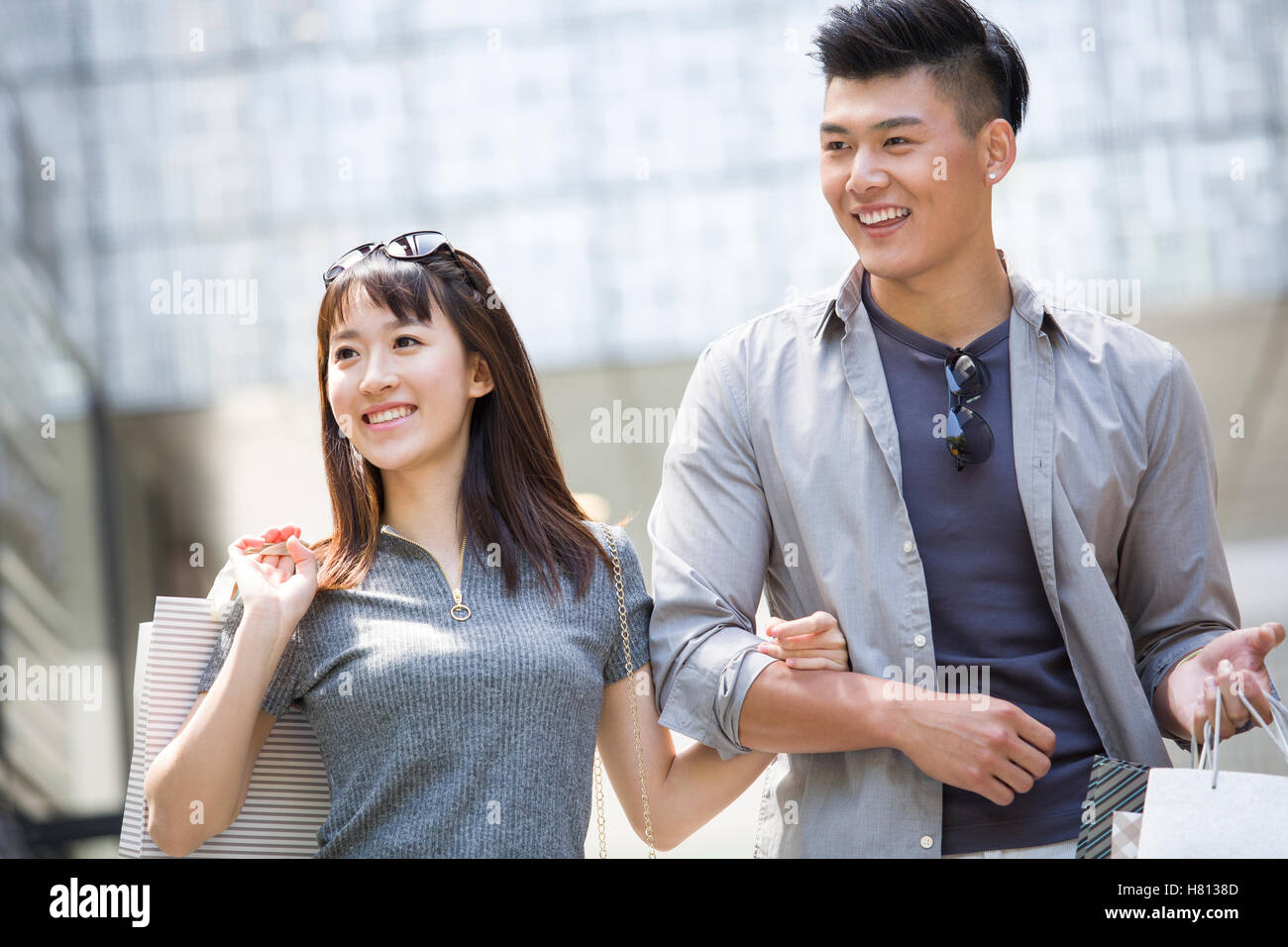 Happy young Chinese couple with shopping bags Stock Photo - Alamy