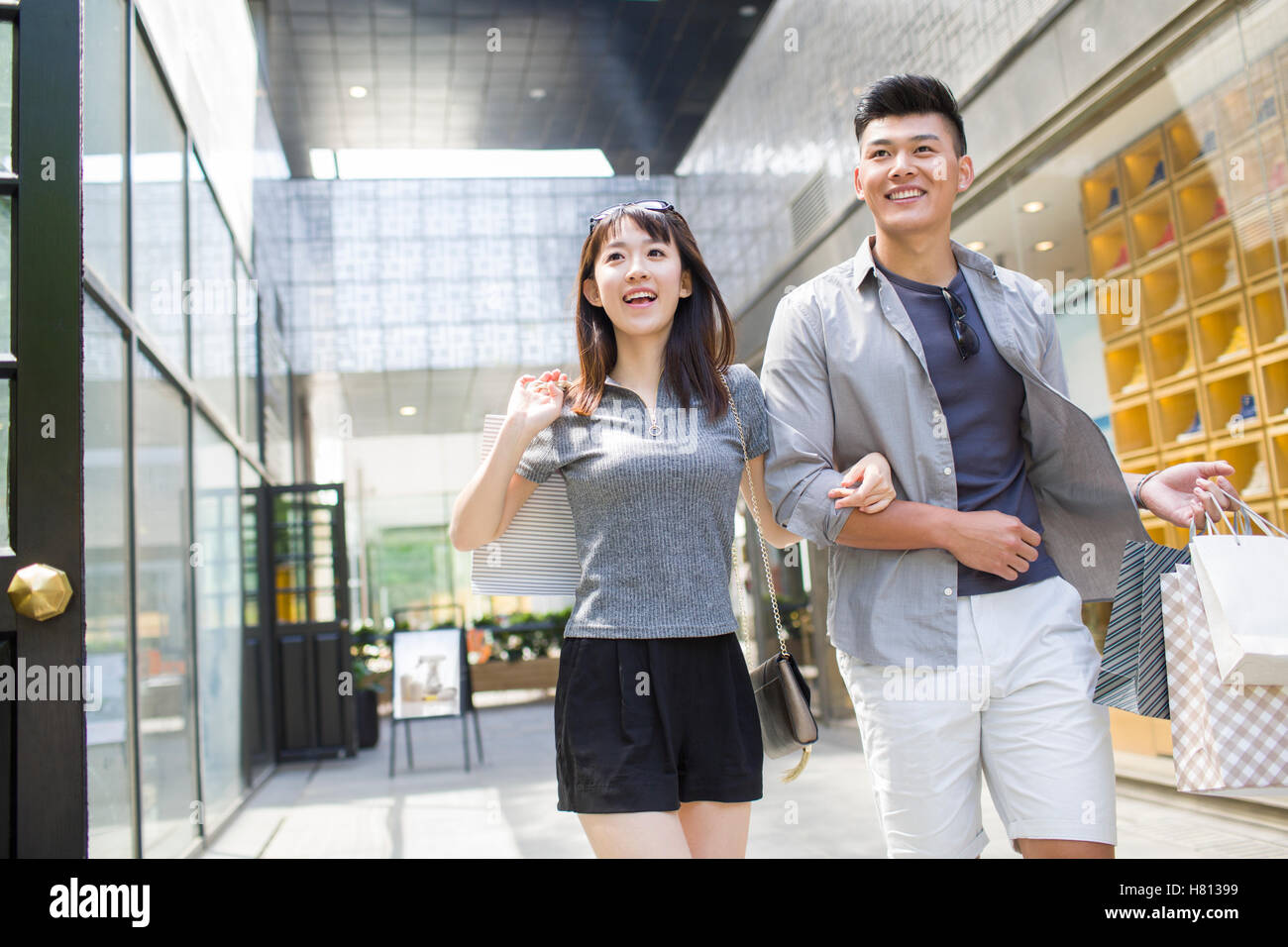 Happy young Chinese couple with shopping bags Stock Photo - Alamy
