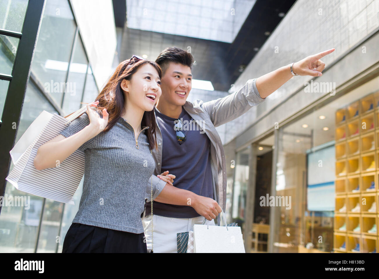 Happy young Chinese couple with shopping bags Stock Photo - Alamy