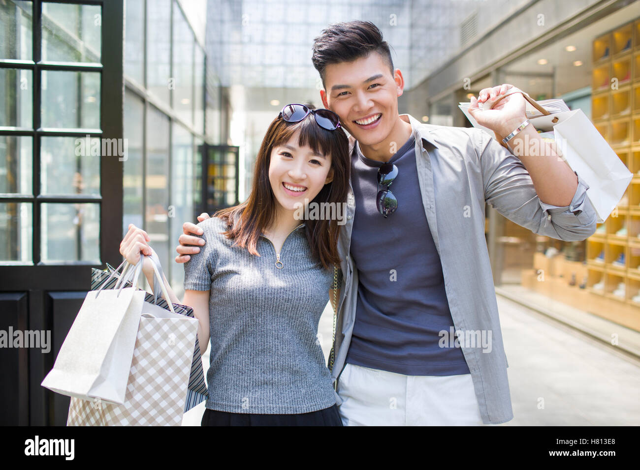 Happy young Chinese couple with shopping bags Stock Photo - Alamy