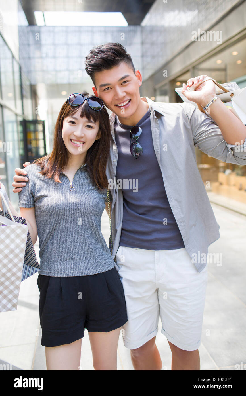 Happy young Chinese couple with shopping bags Stock Photo - Alamy
