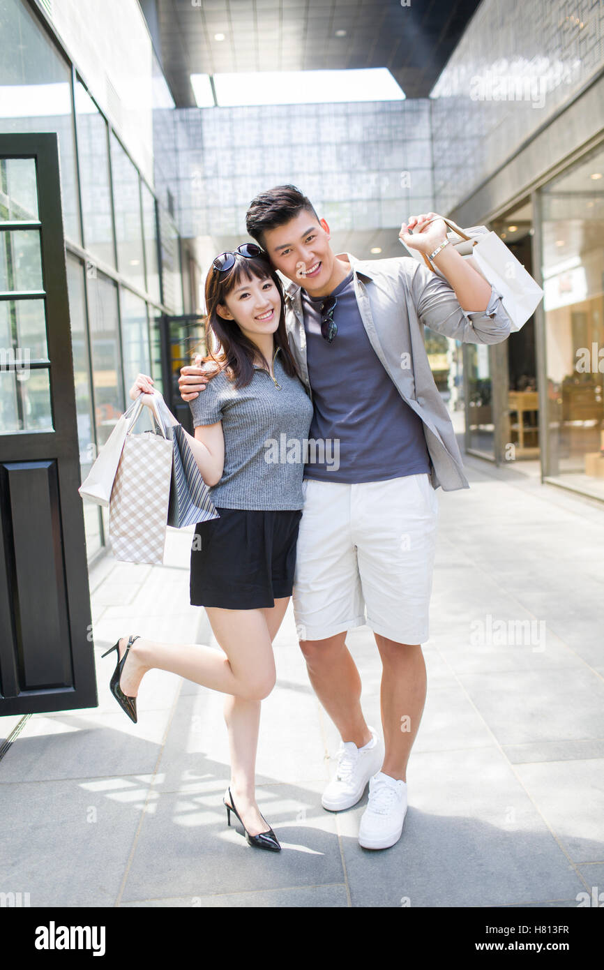 Happy young Chinese couple with shopping bags Stock Photo - Alamy