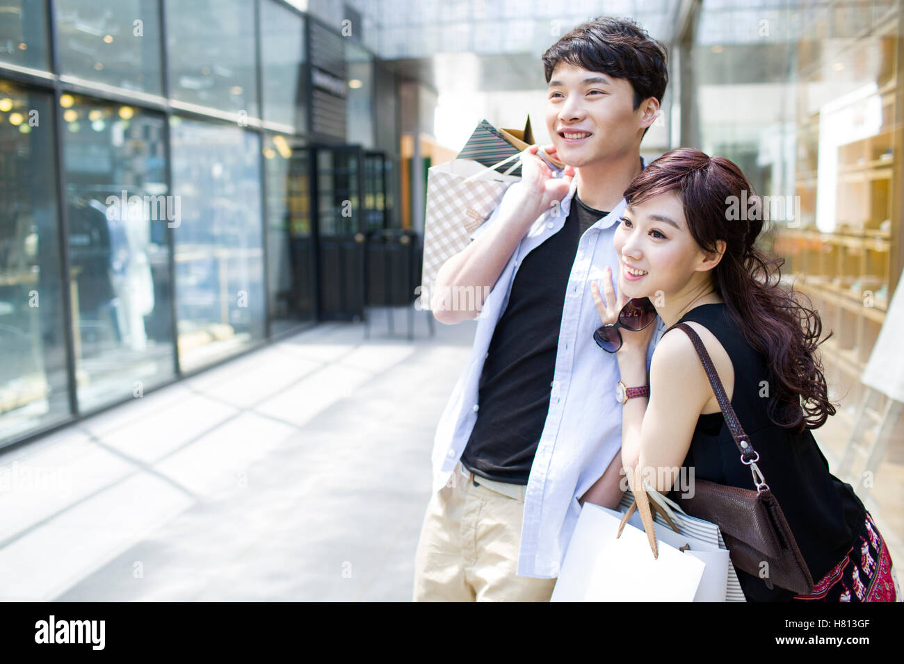 Happy young Chinese couple with shopping bags Stock Photo - Alamy