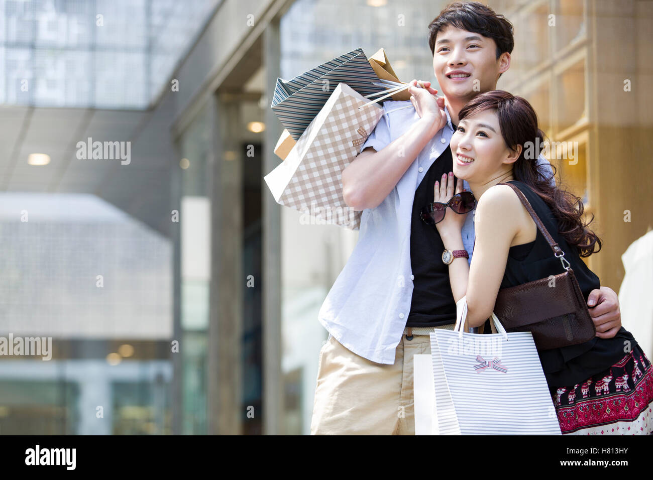 Happy young Chinese couple with shopping bags Stock Photo - Alamy