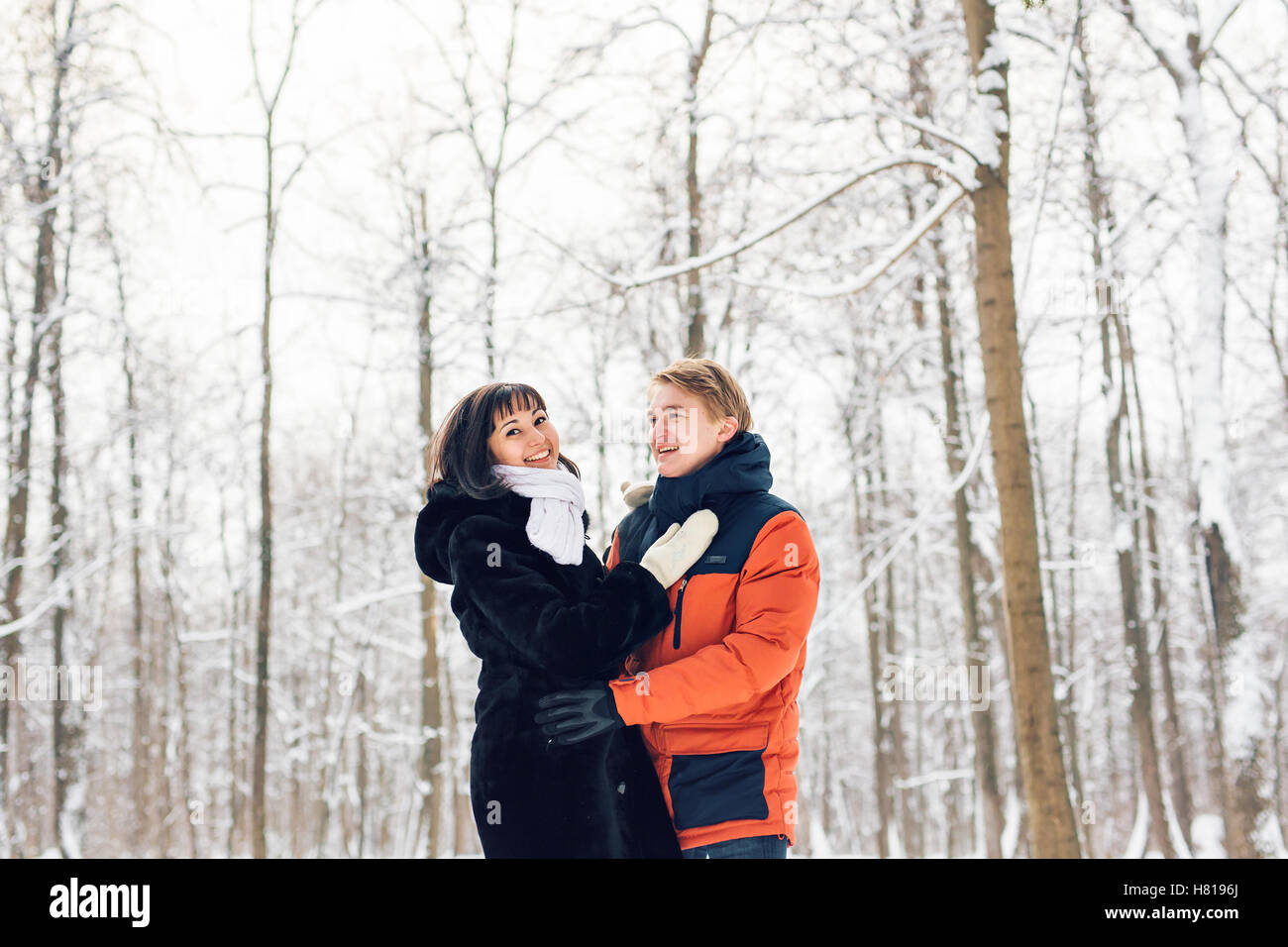 Young couple in love walking in the snowy forest Stock Photo - Alamy