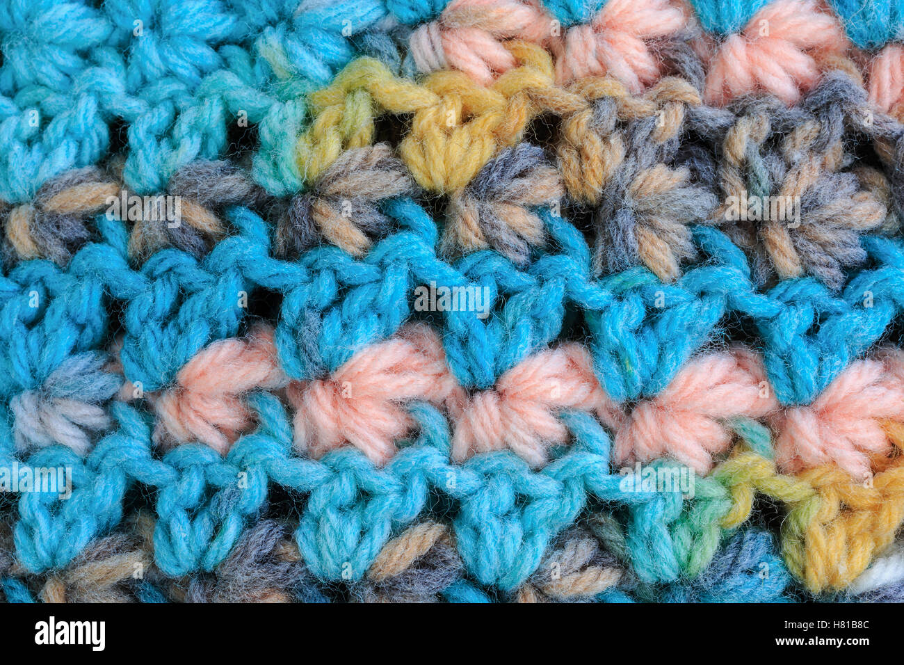 Detail of some crochet fabric showing rows of the shell stitch in a baby sweater. Stock Photo