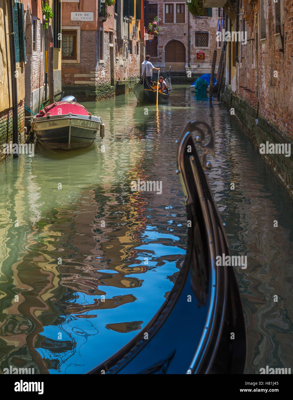 Venice, Venice Province, Veneto Region, Italy.   Gondolo ride through one of the small canals. Stock Photo