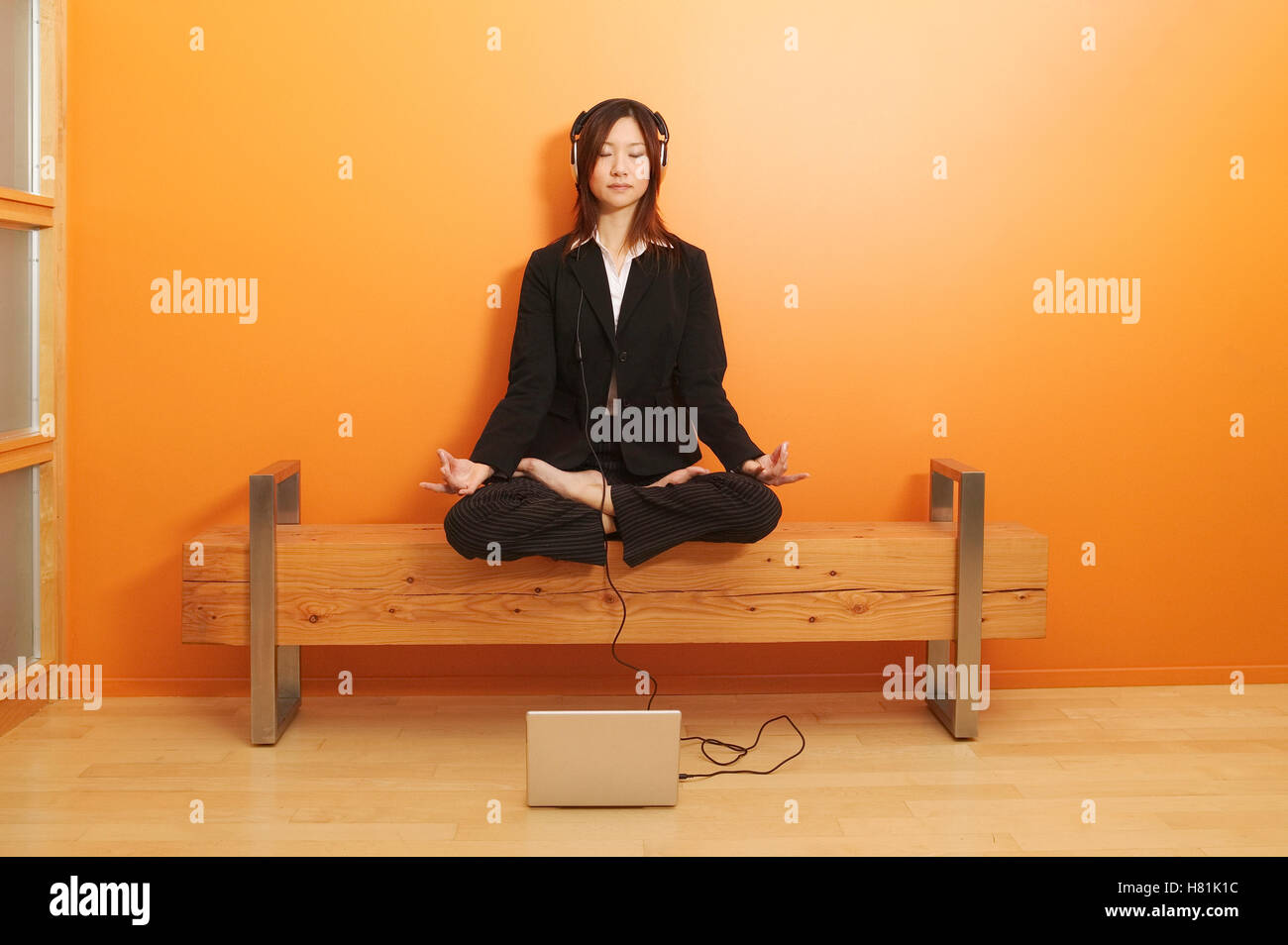 woman relaxing in the lotus position while listening to music Stock Photo