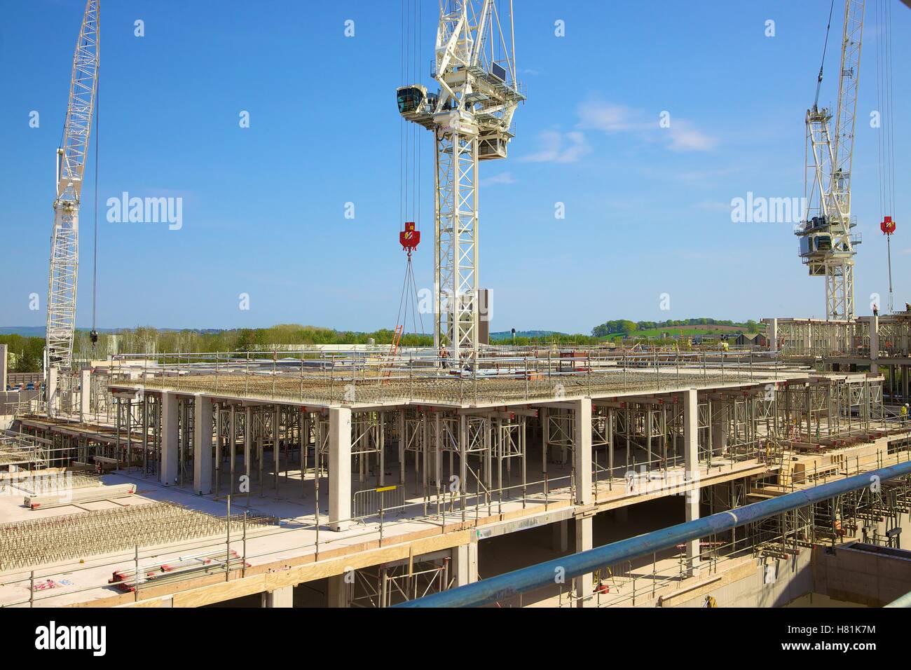 Construction using a crane. Workers wearing safety clothing on the building site. Stock Photo