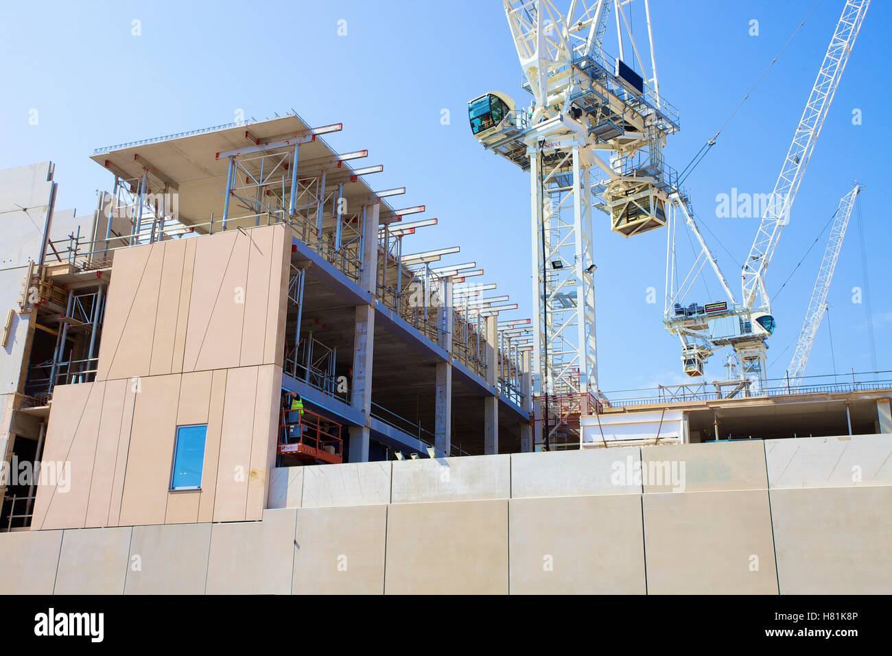 Curtain wall construction using tower cranes. Stock Photo