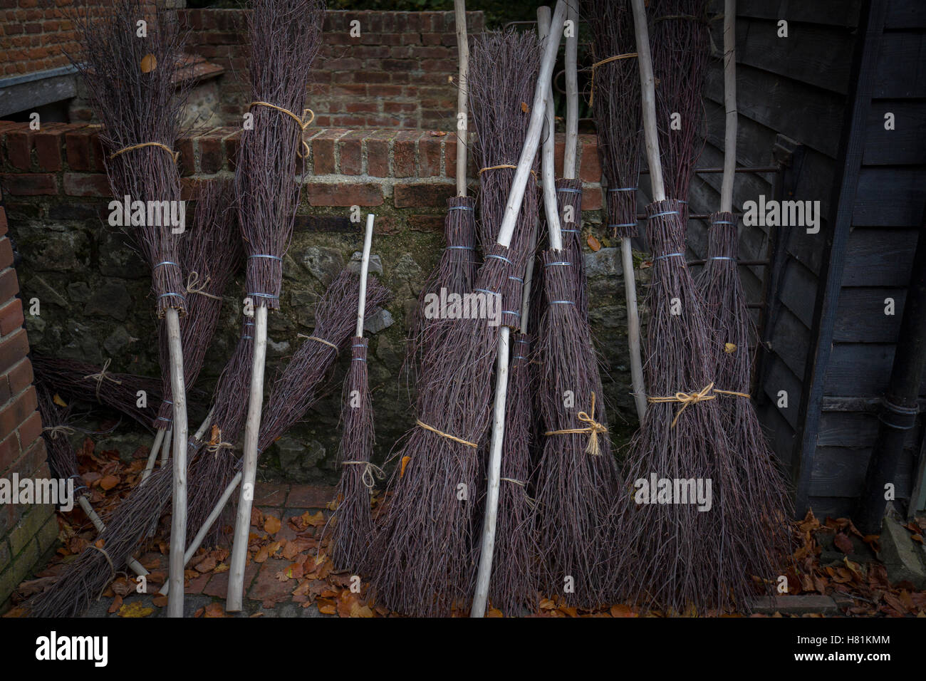 A line of hand made besom brooms. Stock Photo