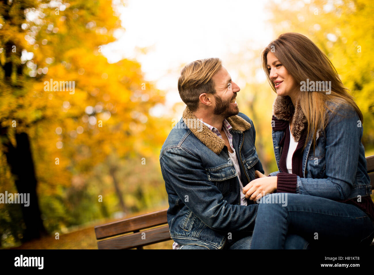 Loving and romantic couple on a bench in the autumn park Stock Photo