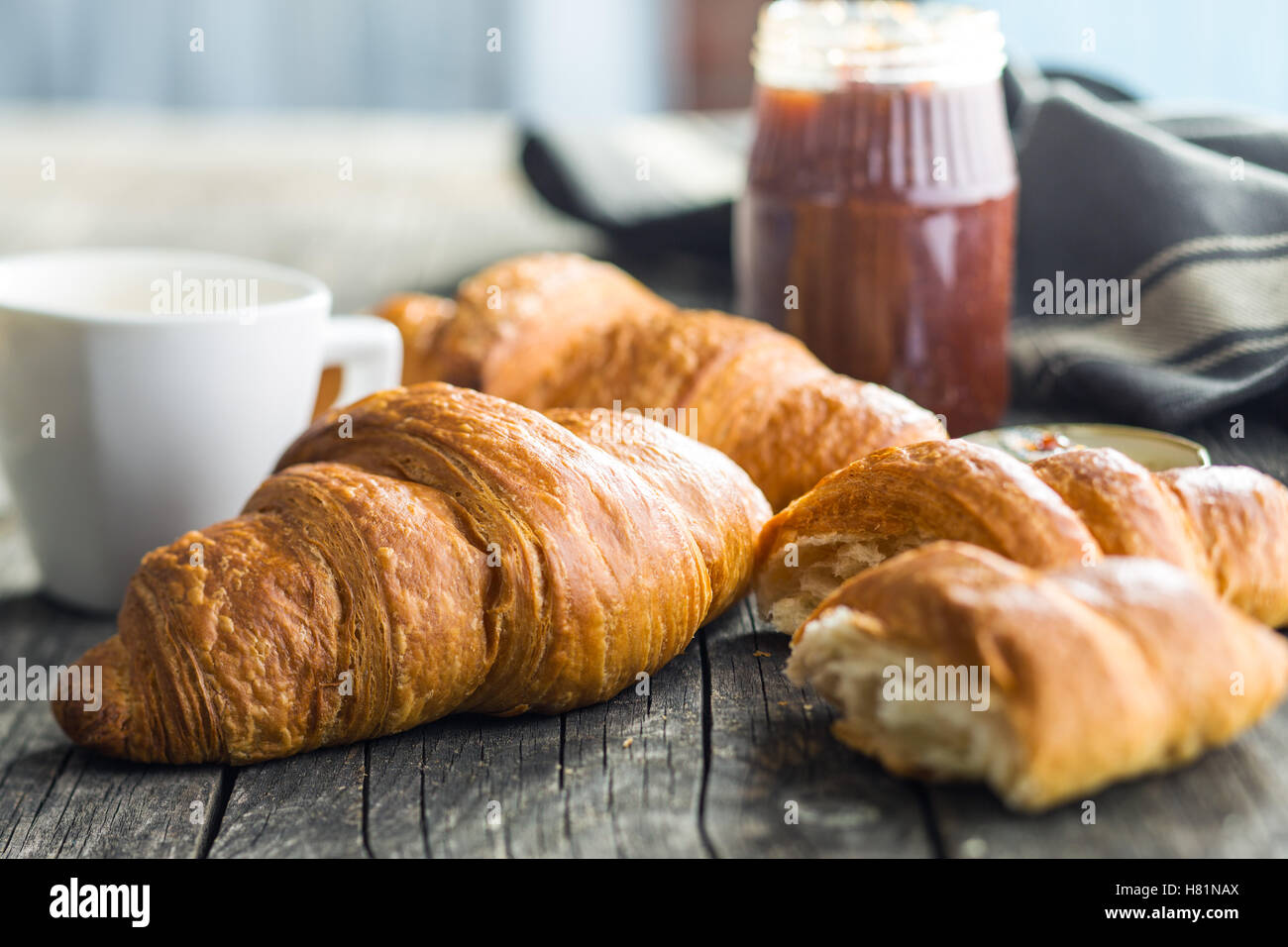 Tasty buttery croissants on old wooden table. Stock Photo
