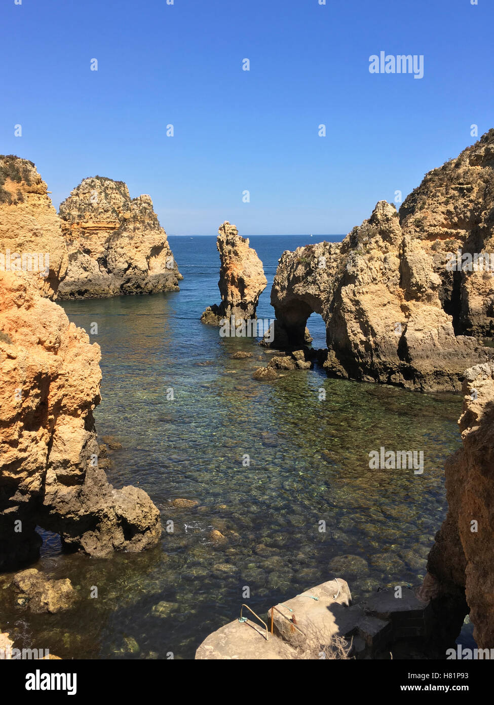 Old rocky outcroppings surrounded by low tide with calm ocean in background. Includes space for boat or copy. Stock Photo