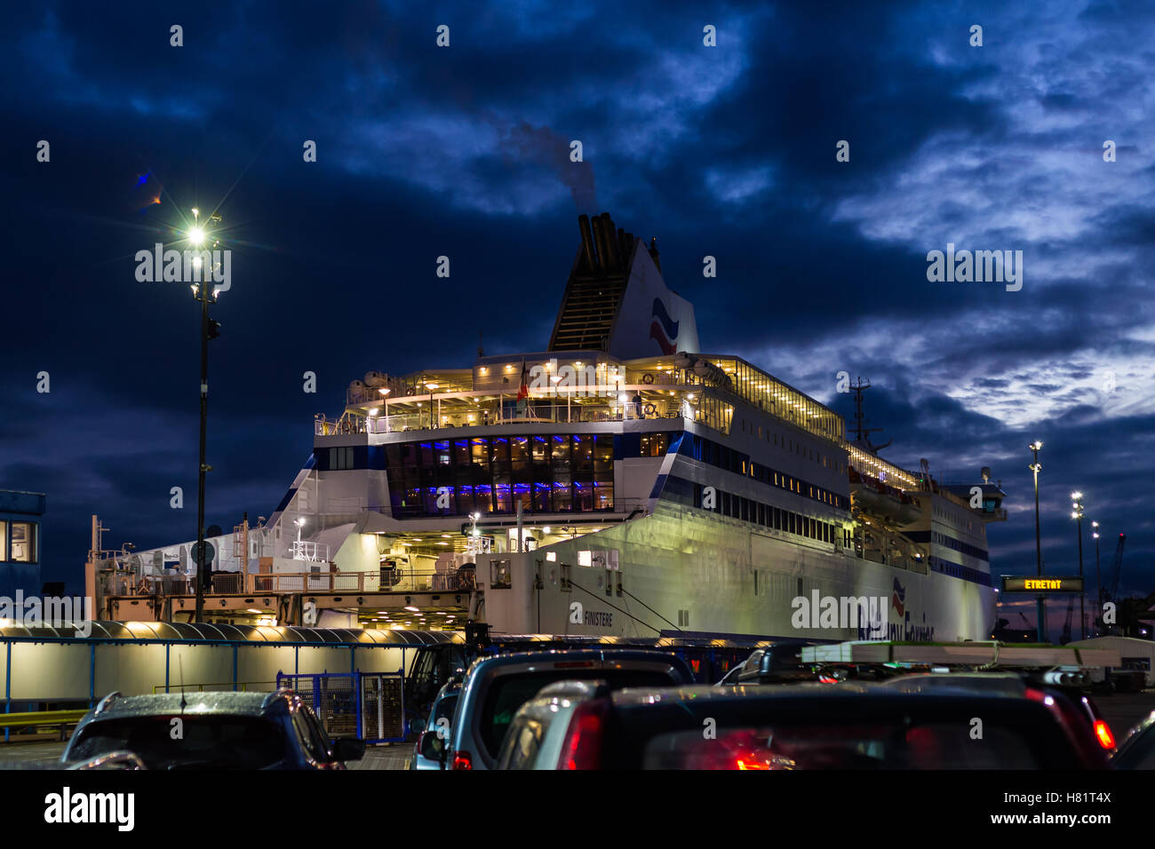 Cars waiting to board ferry in port at night Stock Photo