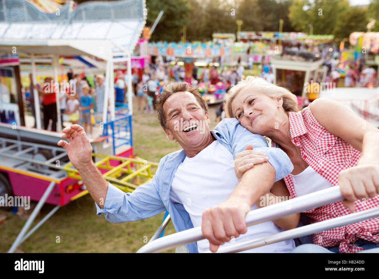 Senior couple on a ride in amusement park Stock Photo