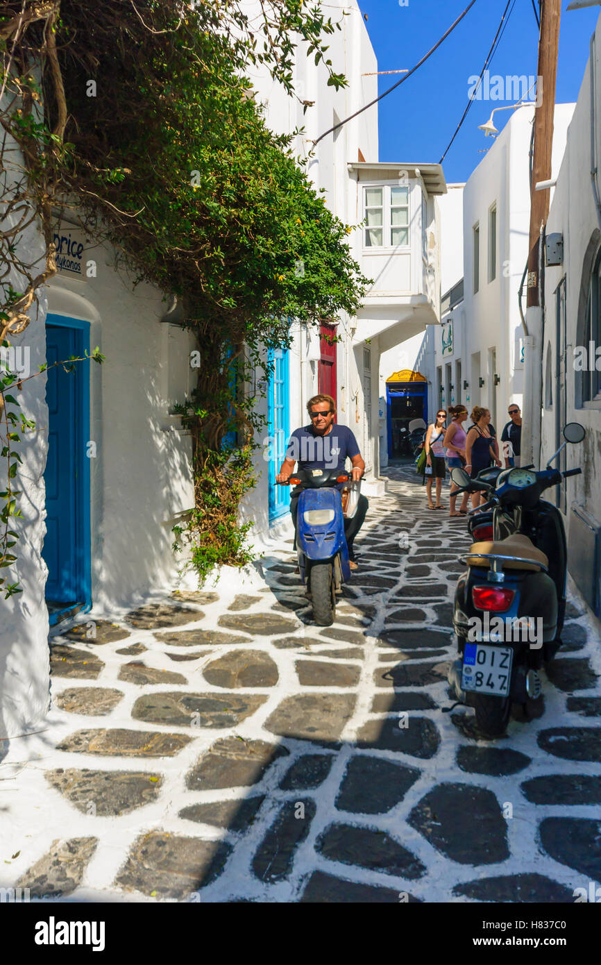 MYKONOS, GREECE - OCTOBER 03, 2011: A Street with typical Greek houses, local businesses, locals and visitors, in Mykonos, Mykon Stock Photo