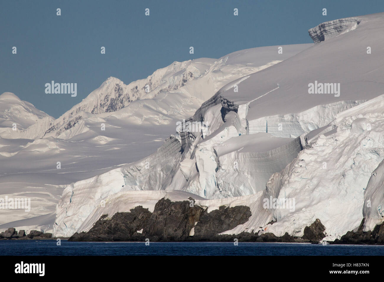Glacier covered Melchior Islands with peaks of Brabant Island in background, Antarctica Stock