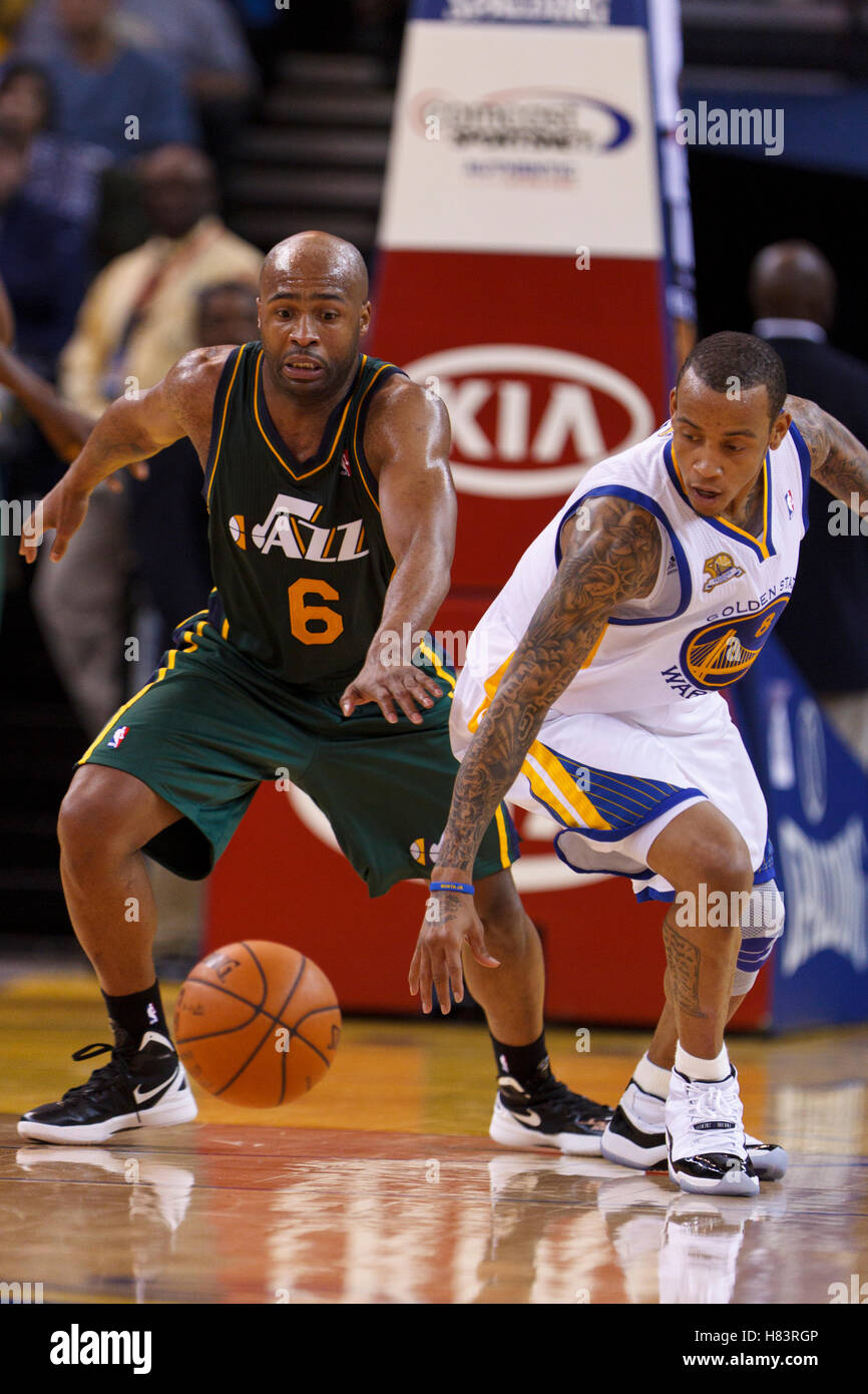 Feb 2, 2012; Oakland, CA, USA; Utah Jazz point guard Jamaal Tinsley (6) and Golden State Warriors shooting guard Monta Ellis (8) reach for a loose ball during the fourth quarter at Oracle Arena. Golden State defeated Utah 119-101. Stock Photo