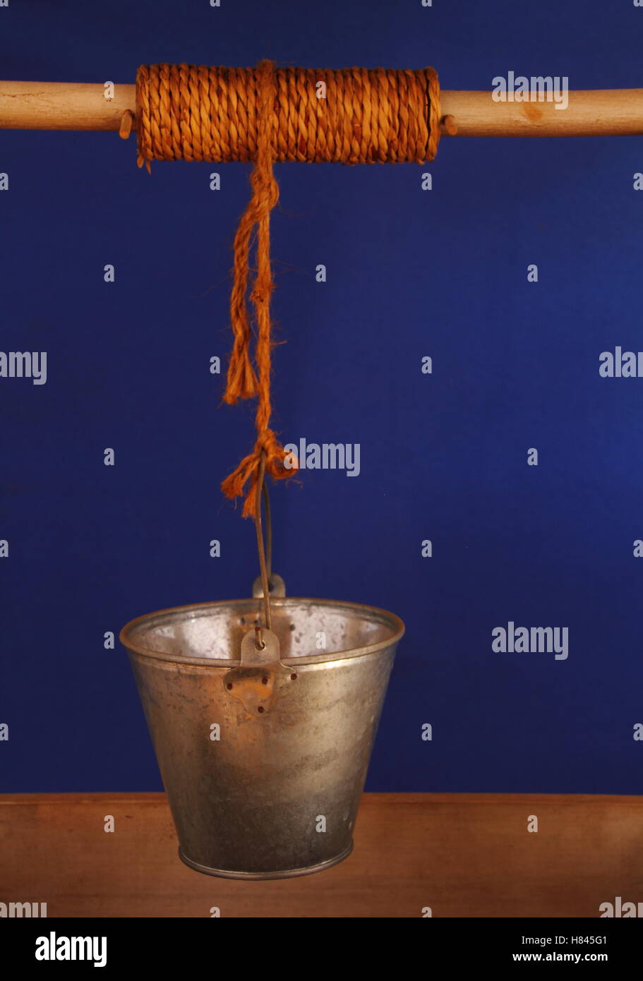 Bucket isolated hanging over a wishing well image in portrait format with copy space Stock Photo