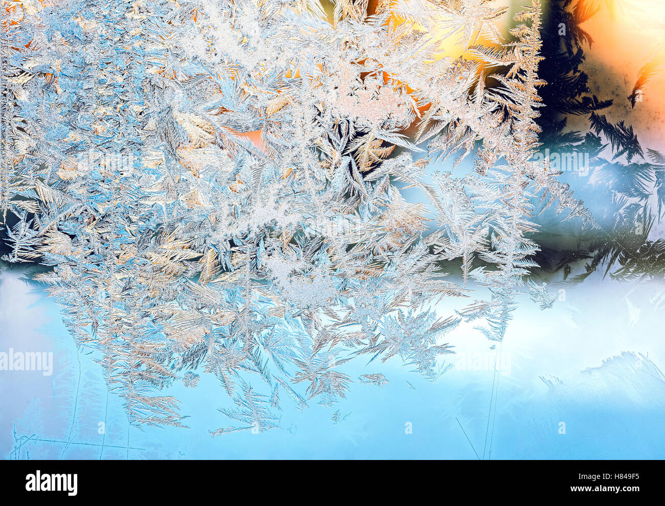frozen window glass with frosty pattern and sunlight Stock Photo
